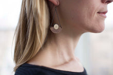 Model wearing walnut wood chandelier earring in graphite with silver centers by Bird of Virtue