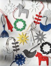 Collection of brightly colored metal ornaments laid on a white marble surface.