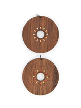 Wooden earrings with circular design and open circle center on a white background