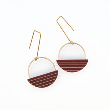 Pair of earrings with gold frames and dark red and gold half-circle designs on a white background