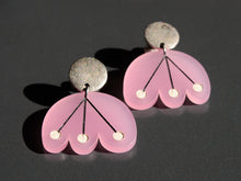 Pink flower earrings with white dots and black lines hang from circular silver post by Bird of Virtue
