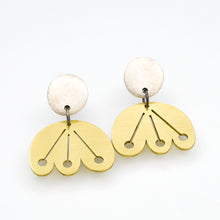 Pair of brass earrings with silver posts on a white background