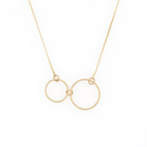 Gold necklace with two small gold circles on a white background by Bird of Virtue