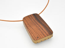 Wooden pendant on a white background with leather cord by bird of virtue