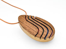 Wooden pendant on leather cord on a white background