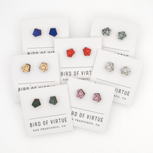 The image shows several pairs of polygon shaped earrings on display cards from "Bird of Virtue" in San Francisco, CA.