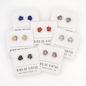 The image shows several pairs of polygon shaped earrings on display cards from "Bird of Virtue" in San Francisco, CA.