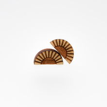 Two semi-circle wooden earrings with sunray or fan pattern featuring light and dark brown contrasting wood tones.
