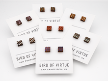 Bird of Virtue, San Francisco, square wooden stud earrings with laser-engraved checkerboard patterns in various colors, displayed on white branded cards.