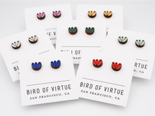 A display of colorful stud earrings with floral designs on white cards from Bird of Virtue, San Francisco. Featuring red, gold, silver, cobalt, mint, green and orchid.