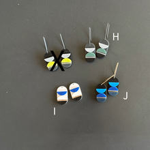 Set of geometric earrings on a gray background