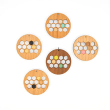 Set of wooden coasters with honeycomb design and colorful centers on a white background
