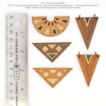 Geometric wooden pendants with a ruler for scale on a white background