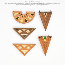 Wooden geometric pendants with various color combinations on a white background.
