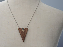 Wooden triangle pendant necklace on a mannequin with a plain background