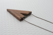 Wooden triangle pendant on a chain against a white background