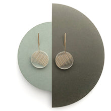 Clear frost circle earring with gold geometric lines and gold hooks on white background