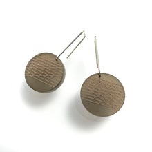 bronze circular earring with rose gold geometric lines and silver hooks on white background
