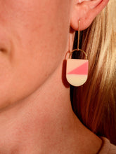 Close-up image wearing pink & cream colored  oblong earring. Bird of Virtue