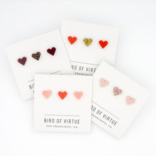 white background with four carded heart shaped stud earrings 