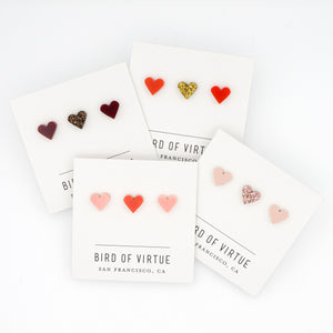 white background with four carded heart shaped stud earrings 