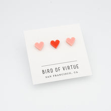 white background with red and pink heart shaped stud earrings on white card