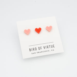 white background with red and pink heart shaped stud earrings on white card