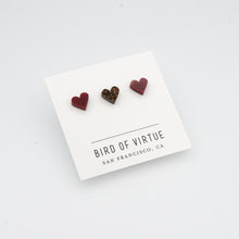 white background with burgundy and rust glitter heart shaped stud earrings on white card