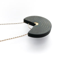 grey and gold necklace with concentric rings on white background