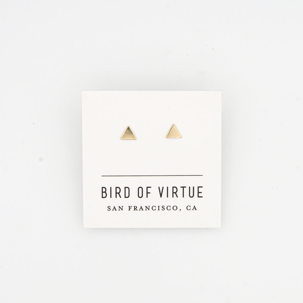 Tiny gold triangle stud earrings on white Bird of Virtue card, on white background